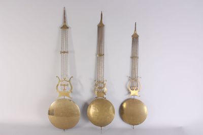 three clocks hanging on the wall with chains attached to them