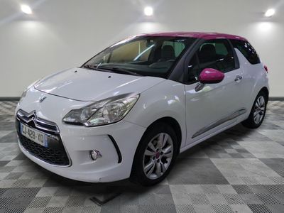 the small white car is parked in a room with a checkered floor
