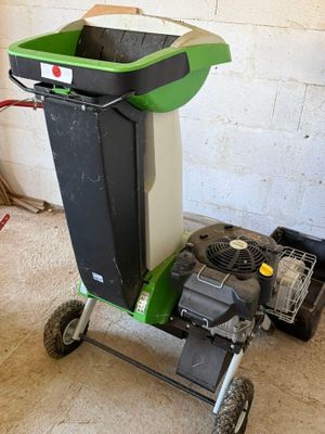 une poubelle verte et noire posée sur un chariot dans un garage