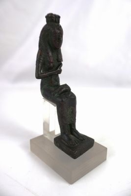 statue représentant un homme assis sur un tabouret, les mains posées sur les genoux