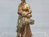 statue en bronze représentant une femme tenant un bébé dans une vitrine en verre