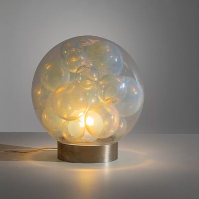 une lampe posée sur une table à côté d'un mur