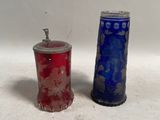 une paire de vases en verre bleu et rouge posés sur une surface blanche
