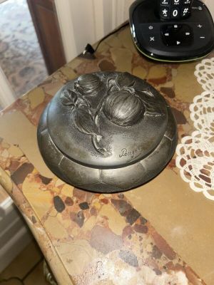a silver plate sitting on a table next to a clock