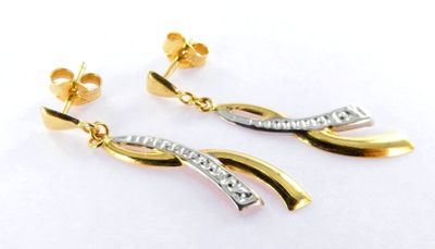 a pair of gold and silver earrings with diamonds