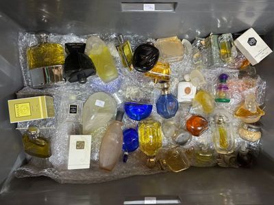 a metal container filled with bottles of perfume and other items