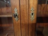 a wooden cabinet with a glass door and a keyhole