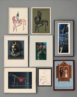 many framed pictures hanging on the wall above a bed