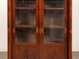 an image of a wooden cabinet with glass doors in a room