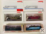 trois trains miniatures dans leurs boîtes, empilés les uns sur les autres