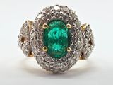 bague ovale en émeraude et diamant sur fond blanc