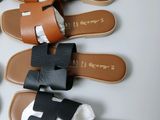 several pairs of sandals are lined up on a white surface