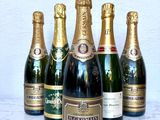 six bouteilles de champagne sont alignées sur une table