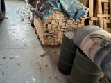 a man that is standing next to a pile of wood