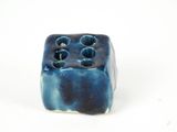 a blue vase with holes in it on a white surface