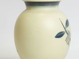 a white vase with a blue design on it