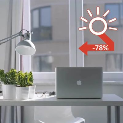 a laptop computer sitting on a desk in front of a window
