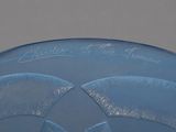 a blue frisbee with writing on it sitting on a table