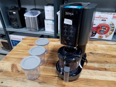 a black coffee maker on a wooden table in a store