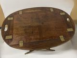 une petite table en bois ornée de détails en laiton