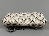 a white and black beaded clutch bag with chain strap