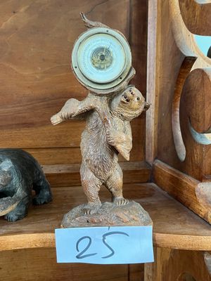 une étagère en bois sur laquelle se trouvent une horloge et une statuette d'ours