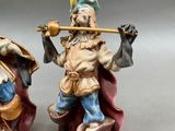 two figurines of a man playing a flute and a woman playing a flute