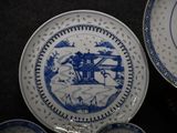 two plates with blue and white designs on them on a table