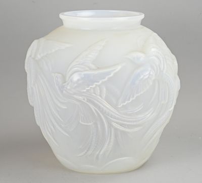 un vase blanc orné d'un oiseau, posé sur une table