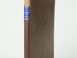 un vieux livre marron avec un marque-page bleu sur la couverture