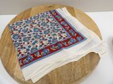 a white table cloth with a blue and red design on it