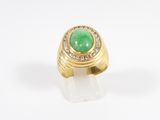 a close up of a gold ring with a green stone surrounded by diamonds