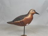 a small bird that is standing on a wooden stand