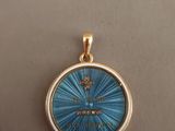 une image représentant un pendentif doré et bleu orné d'une croix