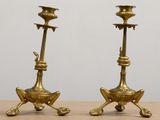 pair of antique brass candlesticks on stand on table