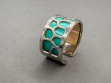 un gros plan d'une bague en argent sertie d'une turquoise