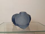 a glass shelf with a blue vase on it