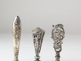 two silver spoons and a silver spoon with a lion head on them
