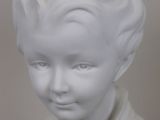 white marble bust of a boy with curly hair wearing a sweater