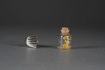 a small bottle of liquid next to a fork on a table