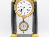 a black and gold clock sitting on top of a table