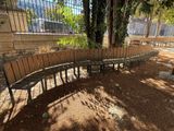 a wooden bench that is next to a fence