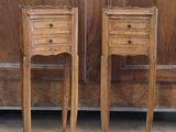 two wooden tables with drawers on them in front of a wooden door