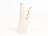 a white vase that has a branch in it