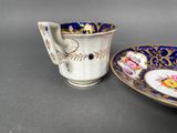 a cup and saucer sitting next to each other on a table