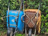 two lawn mowers sitting next to each other in the grass