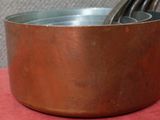 une casserole en métal contenant une cuillère, posée sur un torchon rouge