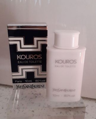 un flacon d'eau de toilette Kouros posé à côté d'une boîte sur un comptoir
