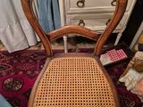 a wooden chair sitting on top of a rug next to a dresser