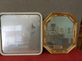 deux miroirs posés l'un à côté de l'autre sur une table rouge